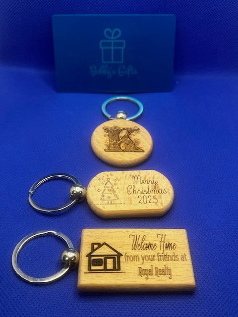 Three wooden keychains with engraved text on a blue background